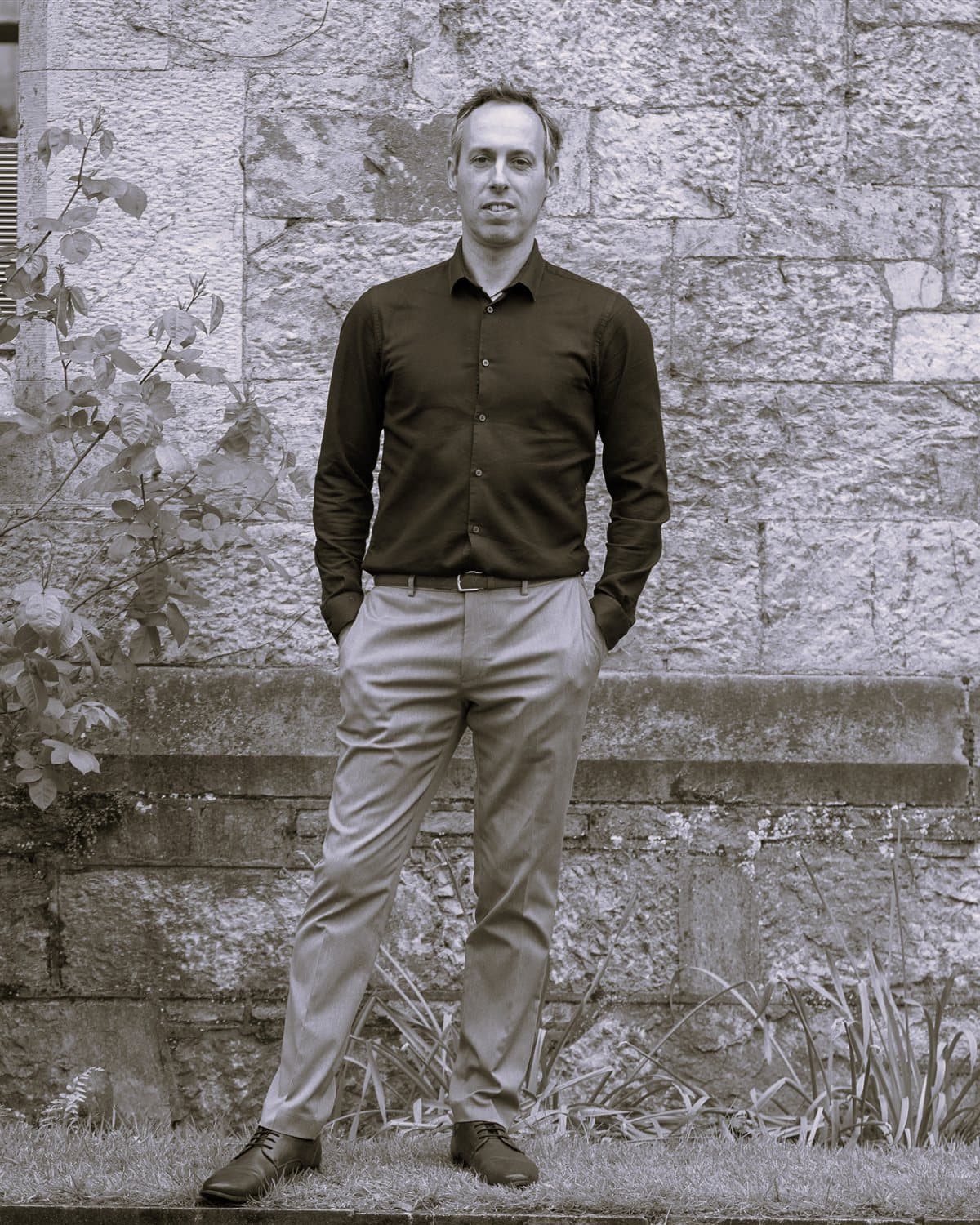 Jeff Gomez standing in front of a stone wall